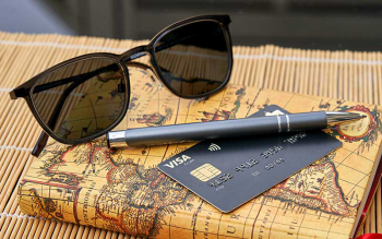 Reisetagebuch mit Sonnenbrille und Deutschland-Kreditkarte