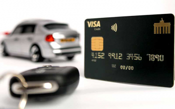 Deutschland-Kreditkarte mit einem Autoschlüssel vor einem silbernen Auto