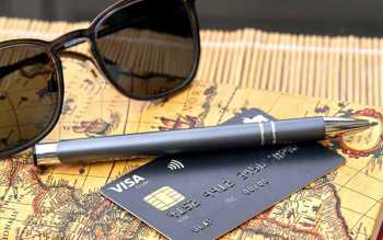 Reisetagebuch, Sonnenbrille, Stift und Kreditkarte liegen für die Reise bereit